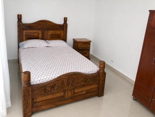 a bedroom with a wooden bed and two night stands at Finca fercho rozo in Rozo