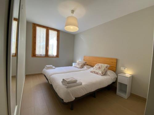a bedroom with a bed with towels on it at Apartamento Casa Francho in Panticosa