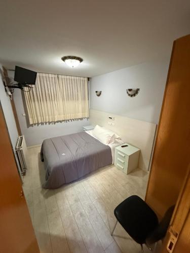 a bedroom with a bed and a table and a chair at Hostal Arévacos in Soria