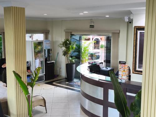 a lobby of a store with plants and a counter at Florença Hotel in Quedas do Iguacu