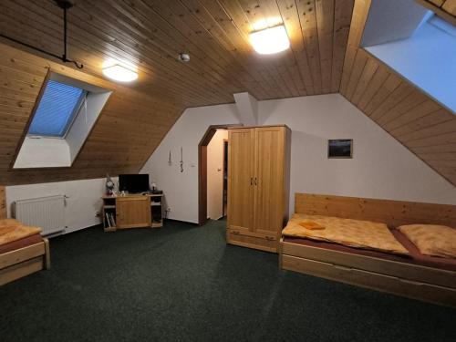 an attic room with two beds and a window at penzion ŽEROTÍN in Staré Město