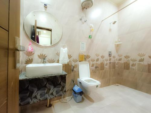 a bathroom with a sink and a toilet and a mirror at The Hideout Agra Garden Homestay - Near Taj Mahal in Agra