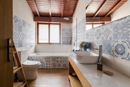 a bathroom with a sink and a toilet and a tub at Casas da Aldeia da Graça in Guimarães