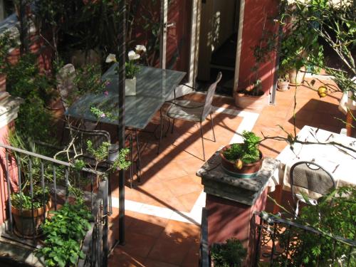a patio with a table and chairs and potted plants at B&B L'Orto Sul Tetto in Ragusa