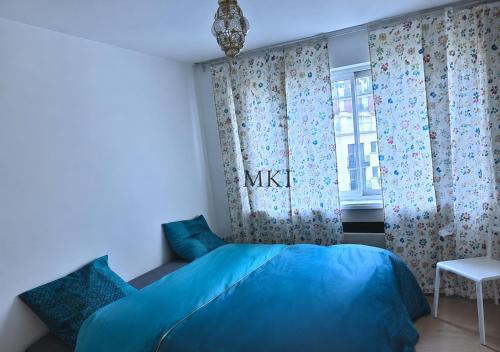 a bedroom with a blue bed and a window at Eiffel Tower spacious 2-bedroom, 2-bathroom quiet apartment, elegant and peaceful in Paris