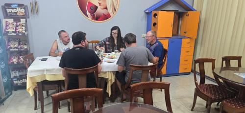 a group of people sitting around a table in a restaurant at Hotel Bar Restorant Marina in Mjedë