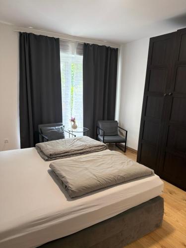 a bedroom with a bed and a chair and a window at Hansehaus Lübeck - Stadtnest in Lübeck