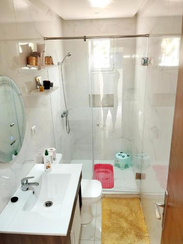 a white bathroom with a shower and a sink at Luxury big House in hearth of Hay Riad with big garden in Rabat