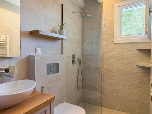 a bathroom with a sink and a glass shower at Villa Agia Marina in Skopelos Town