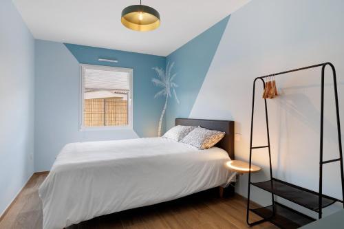 a bedroom with a white bed and a blue wall at Gite Logeraie in Le Boupère