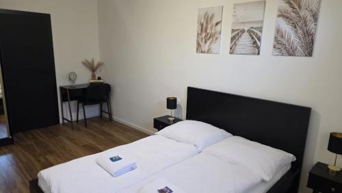 a bedroom with a bed with two white sheets at RG Apartments in Šamorín
