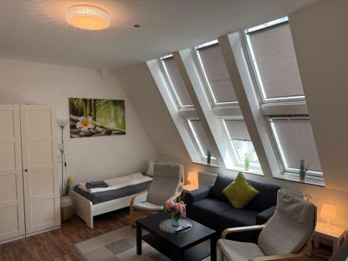 a living room with a couch and two windows at CityApartment Platinum-Zentrum mit Parkplatz in Bielefeld