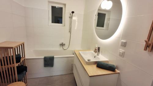 a bathroom with a sink and a tub and a mirror at Gästehaus IWANESTAL in Eibesthal