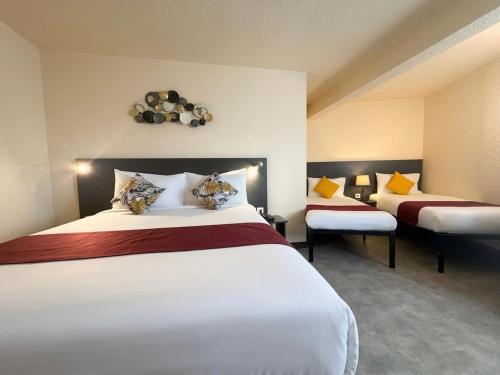 a hotel room with two beds and two chairs at The Originals City, Hôtel Le Forum, Strasbourg Nord in Schiltigheim