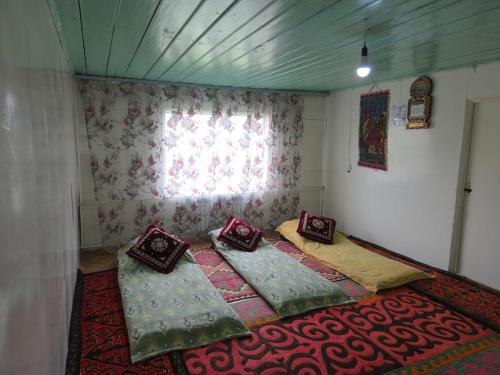 two beds in a room with a window at Dosoi Guest House Experience Song-Kul with Horseback Tours in Kyzylemgek
