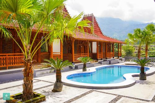 a resort with a swimming pool in front of a building at Instay Villa Dieng Kademangan in Wonosobo