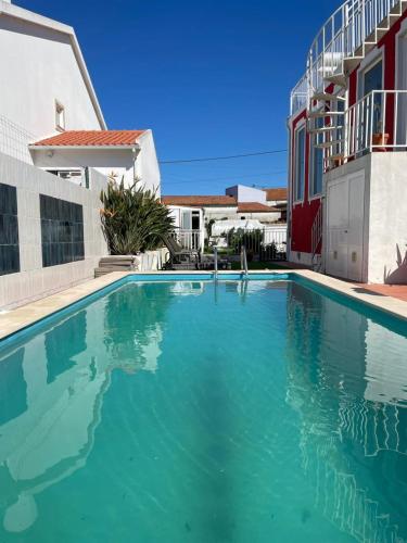 a swimming pool in front of a house at Palacete da Vermelha in Vermelho