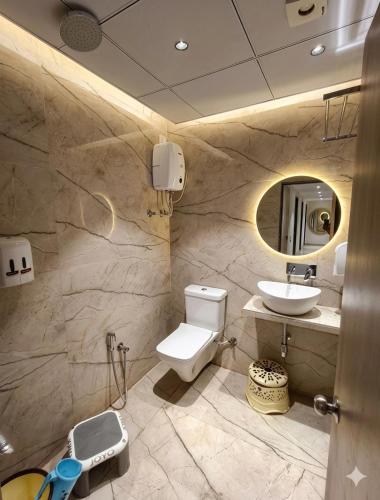 a bathroom with a toilet and a sink at Hotel VD Rooms Althan in Surat