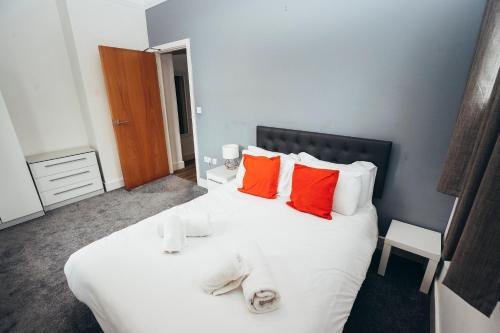 a bedroom with a white bed with red pillows at Dalby House in Derby