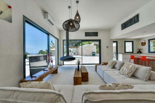 a living room with white furniture and large windows at Caray - Managed by Almarina Villas in Benissa