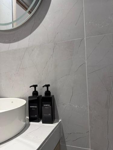 a bathroom with two complimentary soap bottles on a counter at Aura Rooms in Delvinë