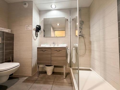 a bathroom with a toilet and a sink and a shower at The Originals City, Hôtel Le Forum, Strasbourg Nord in Schiltigheim