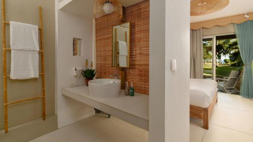 a bathroom with a sink and a mirror at Veranda Pointe Aux Biches Hotel & Spa in Trou aux Biches