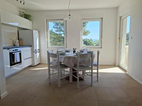 a kitchen with a table and chairs in a room at Sea View Apartments in Selca