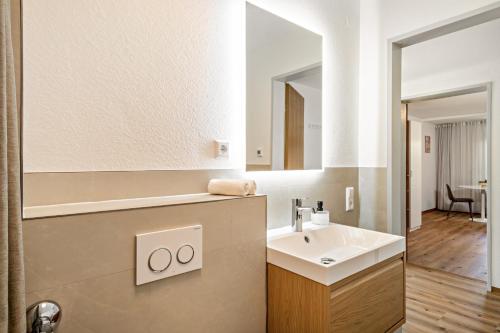 a bathroom with a sink and a mirror at Ferienwohnung am Bächler in Hagnau