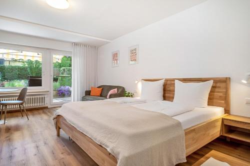 a bedroom with a large bed and a window at Ferienwohnung am Bächler in Hagnau