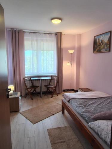 a bedroom with a bed and a table with chairs at Pokoje gościnne u Antka in Krynki