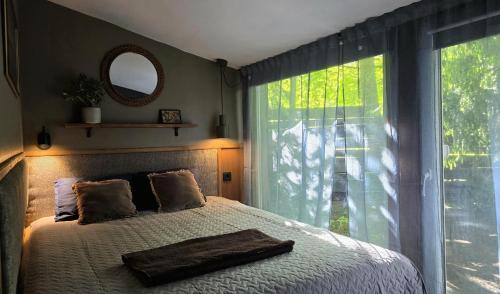 a bedroom with a large bed with a large window at Pirts Rozēni in Saulkrasti
