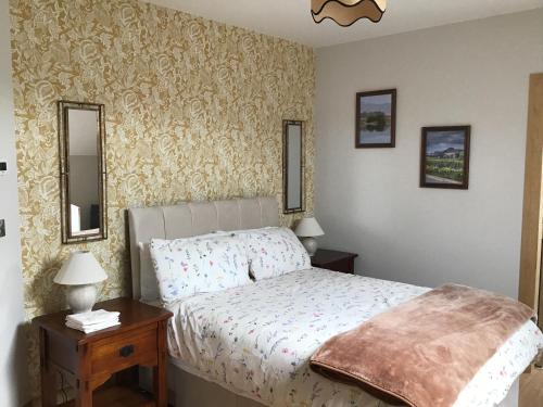a bedroom with a bed and two mirrors on the wall at Craigtown view in Craigtown