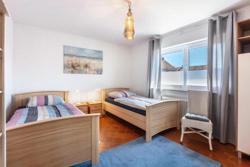 a bedroom with two beds and a window at Landzeit in Efringen-Kirchen