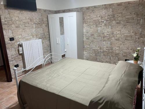 a bed in a room with a brick wall at Il Rifugio nel Matese in San Massimo
