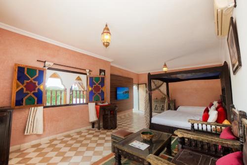 a room with a bedroom with a bed and a couch at Riad Saida Atlas in Marrakesh