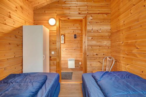 a bedroom with two beds in a wooden cabin at Fins Chalet op vakantiepark in Gramsbergen