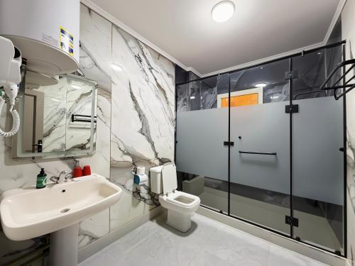 a bathroom with a sink toilet and a shower at JubingeHotel 聚滨阁华人酒店 in Cairo