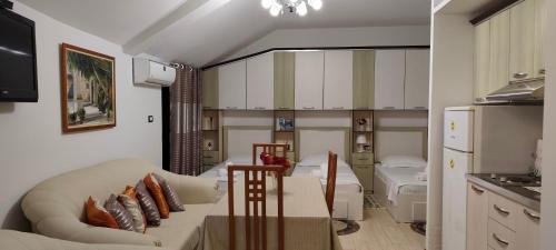 a living room with a couch and a kitchen at Lille France Apartments in Shkodër