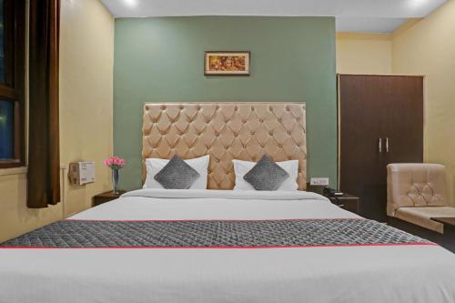 a bedroom with a large bed and a chair at Hotel O Dps Inn in Allahābād