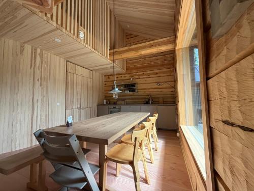 a wooden dining room with a long table and chairs at Handcrafted Log Chalet Villa Aarreaitta in Syöte