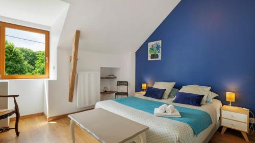 a blue bedroom with a bed with towels on it at Gîte La Longère in Laillé