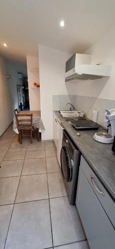 a kitchen with a washing machine and a stove at Maisonette bedogao in Valence