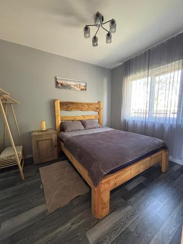 a bedroom with a wooden bed and a window at Dzintarjūras Namiņš 36 in Šķēde