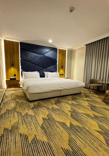 a bedroom with a large bed with a large blue headboard at زون آفينيو للشقق المخدومة Zone avenue in Hafr Al-Batin