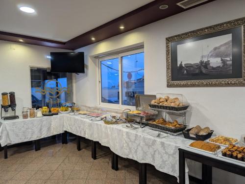 a buffet line with tables with food on them at B&B Berlenga 4 in Nazaré