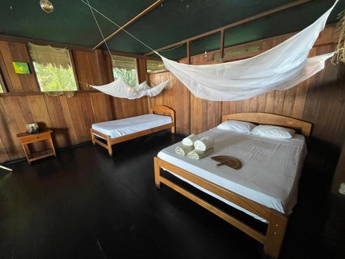 a bedroom with a bed and a hammock at Tambopata Haven lodge in Puerto Maldonado