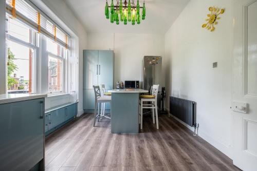 a kitchen with a table and chairs and a chandelier at Culzean Road, Retreat in Maybole