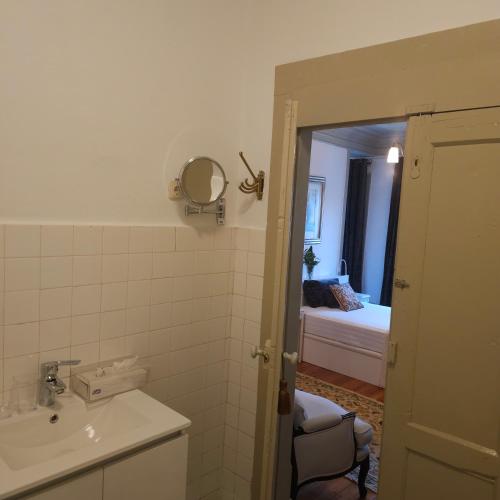 a bathroom with a sink and a mirror and a bed at O Solarinho Azul in Oledo