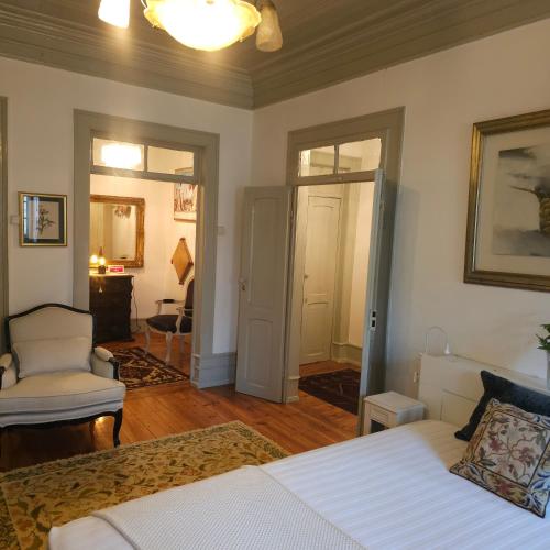 a bedroom with a bed and a chair in it at O Solarinho Azul in Oledo